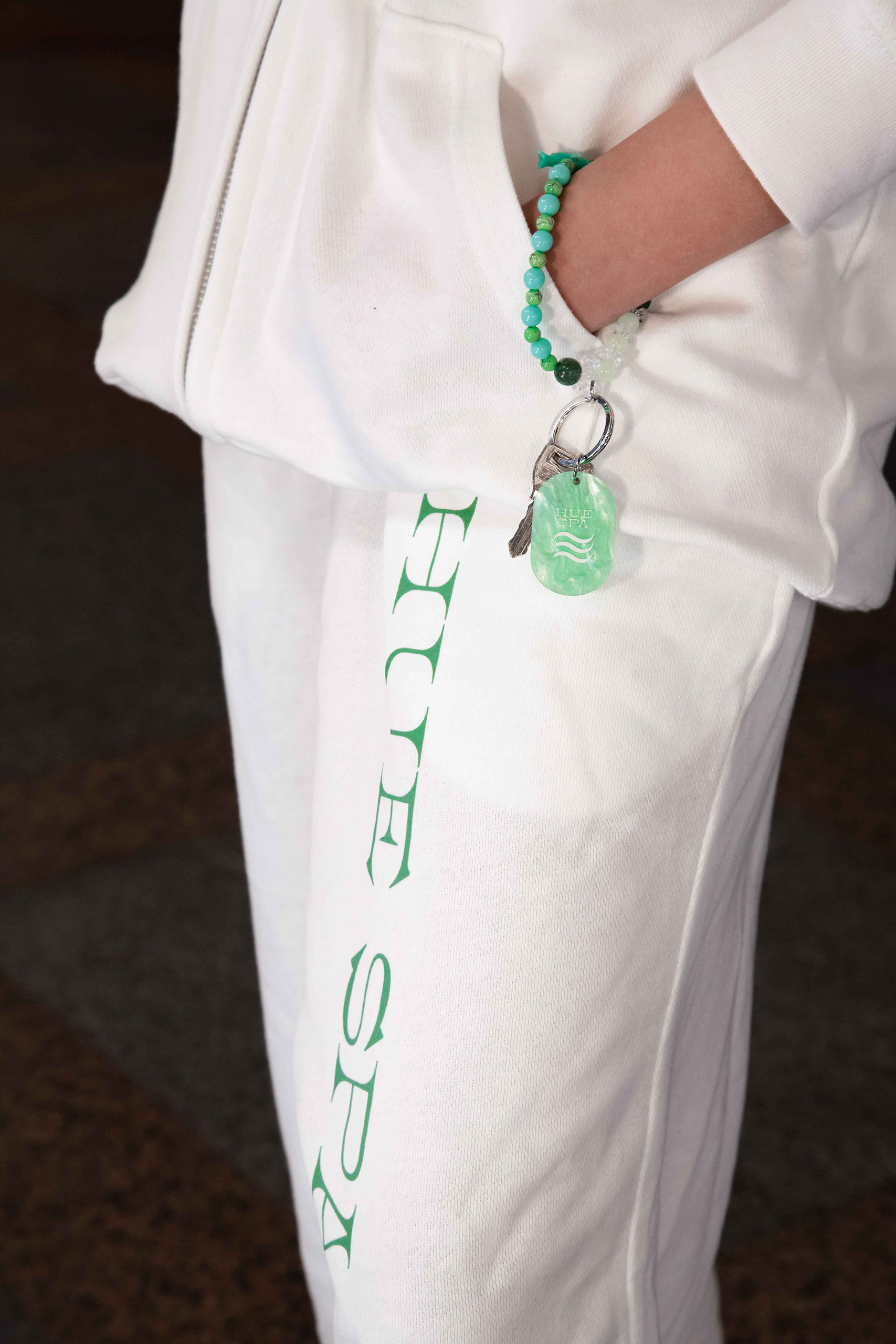 옥구슬 장식이 달린 휴스파 열쇠를 손목에 걸고 서있다.